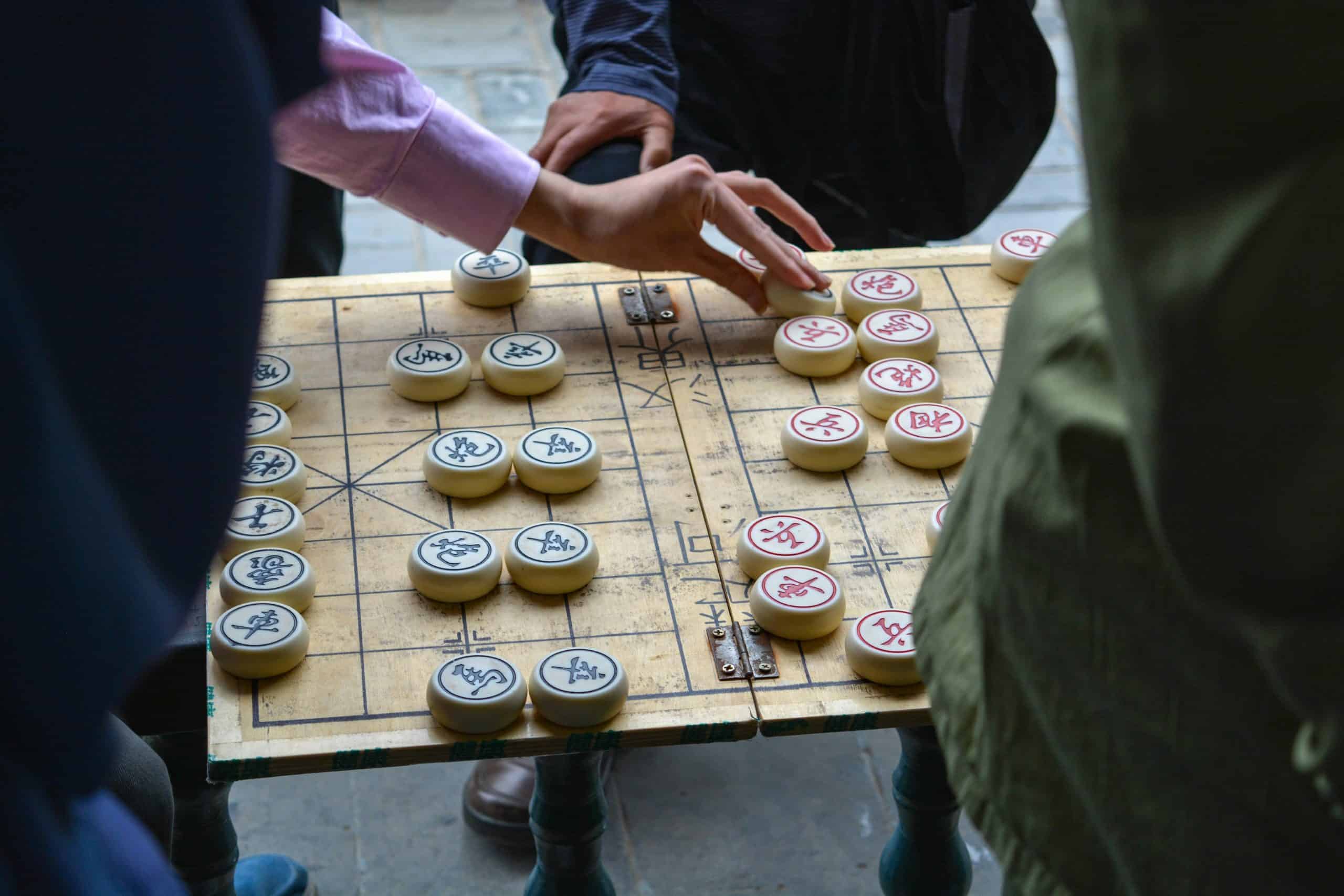 2 people playing a chinese board game on the street